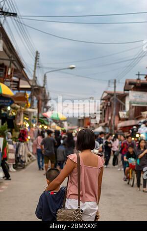 Mutter und Sohn auf der Straße und blurry Touristen zu Fuß Straße Chiang Khan, Loei in Thailand. Stockfoto