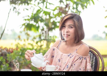 Kessel ist aus Keramik in den Händen der asiatischen Frauen Hintergrund verschwommen Baum gemacht. Stockfoto