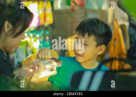 Mutter und Sohn sind Snacks und spielen glücklich zusammen. Stockfoto