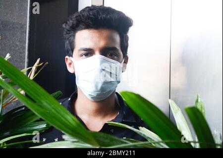 Porträt von schönen jungen Mann mit chirurgischen medizinischen Maske Blick auf die Kamera. Mann in lächelnd. Stockfoto