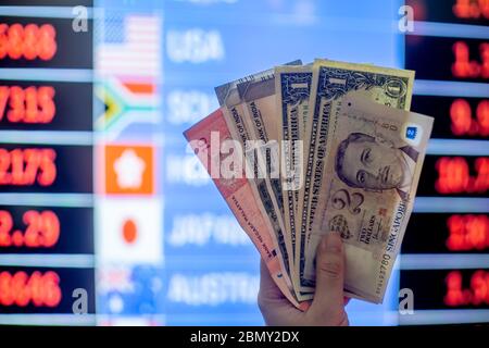 Hände halten mehrere Währungen Noten wie american Dollar, malaysischen Ringgit, singapur-Dollar, indische Rupie mit Backgund eines Wechsels Stockfoto