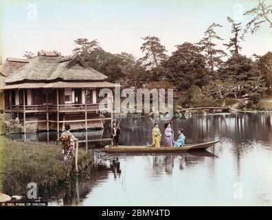 [ 1890er Jahre Japan - Geisha im Japanischen Garten ] - drei junge Frauen und ein Bootsmann stehen in einem kleinen Boot, während zwei andere Frauen im Hakkeitei Pavillion (八景亭) im Genkyuen Garten (玄宮園) in Hikone, Präfektur Shiga, zusehen. Vintage Albumin-Fotografie aus dem 19. Jahrhundert. Stockfoto