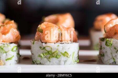 Drei Maki-Rollen in einer Reihe mit Lachs, Aal und Gurke auf weißem Hintergrund isoliert. Frische Hosomaki-Stücke mit Reis und Nori. Nahaufnahme von Delicious Stockfoto