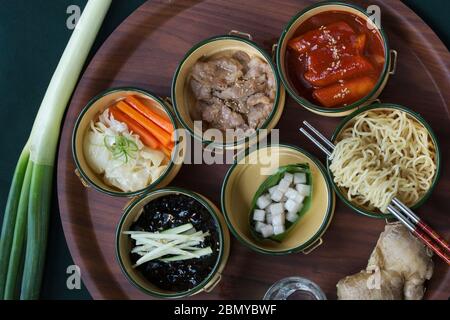 Stilvolle Draufsicht der beliebten koreanischen Nudeln. Die Hauptgerichte sind Jajangmyeon, die schwarzen Nudeln, Sesam rühren gebratenes Schweinefleisch, und tteokbokki, süß und spic Stockfoto