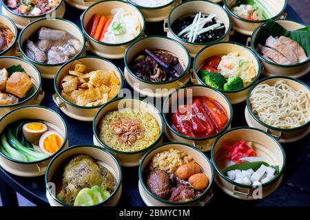 Vielfalt an leckeren asiatischen Gerichten (Japanisch, Koreanisch, Taiwanesisch, Indisch) aus der Draufsicht auf grünem Blatthintergrund Stockfoto