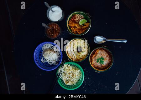 Rohe und gekochte gelbe Eiernudeln, würziges tom Yum-Schweinefleisch und Nudel-Beilage in Pinto-Ansicht-Studio-Aufnahme mit thai-Stil Gewürz serviert umfasst su Stockfoto