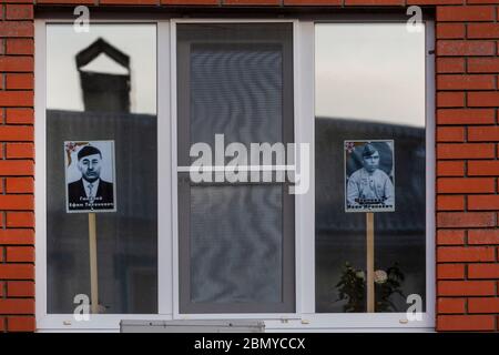 Wolokolamsk, Russland. 9. Mai 2020 Fenster mit Porträts von Menschen, die im Zweiten Weltkrieg als Teil der Aktionen "Fenster des Sieges" und "Unsterbliche Regiment" als Teil der Feier des 75. Jahrestages des Sieges über Nazi-Deutschland im Zweiten Weltkrieg gekämpft Am 16. April 2020 verschob der russische Präsident Putin die Militärparaden und Feierlichkeiten zum Siegestag aufgrund der Novelle COVID-19-Pandemie in Russland Stockfoto