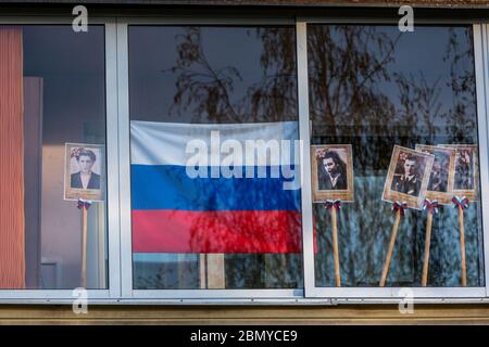 Wolokolamsk, Russland. 9. Mai 2020 Fenster mit Porträts von Menschen, die im Zweiten Weltkrieg als Teil der Aktionen "Fenster des Sieges" und "Unsterbliche Regiment" als Teil der Feier des 75. Jahrestages des Sieges über Nazi-Deutschland im Zweiten Weltkrieg gekämpft Am 16. April 2020 verschob der russische Präsident Putin die Militärparaden und Feierlichkeiten zum Siegestag aufgrund der Novelle COVID-19-Pandemie in Russland Stockfoto