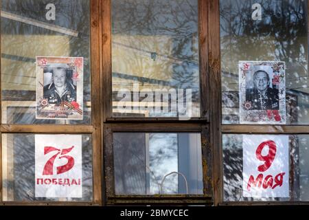 Wolokolamsk, Russland. 9. Mai 2020 Fenster mit Porträts von Menschen, die im Zweiten Weltkrieg als Teil der Aktionen "Fenster des Sieges" und "Unsterbliche Regiment" als Teil der Feier des 75. Jahrestages des Sieges über Nazi-Deutschland im Zweiten Weltkrieg gekämpft Am 16. April 2020 verschob der russische Präsident Putin die Militärparaden und Feierlichkeiten zum Siegestag aufgrund der Novelle COVID-19-Pandemie in Russland Stockfoto