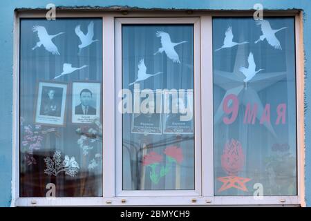 Wolokolamsk, Russland. 9. Mai 2020 Fenster mit Porträts von Menschen, die im Zweiten Weltkrieg als Teil der Aktionen "Fenster des Sieges" und "Unsterbliche Regiment" als Teil der Feier des 75. Jahrestages des Sieges über Nazi-Deutschland im Zweiten Weltkrieg gekämpft Am 16. April 2020 verschob der russische Präsident Putin die Militärparaden und Feierlichkeiten zum Siegestag aufgrund der Novelle COVID-19-Pandemie in Russland Stockfoto