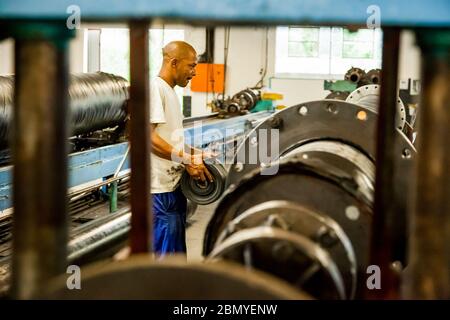 Johannesburg, Südafrika - 19. Oktober 2012: Diverse Arbeiter in einer Gummi- und Rohrfertigungs-Montagelinie in einer Fabrik Stockfoto