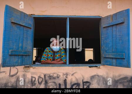 Ein Mann blickt aus dem Fenster auf einen Veranstaltungsort für ein Programm zur sozialen Distanzierung einer Regierungsbehörde in Lagos, Nigeria. Stockfoto