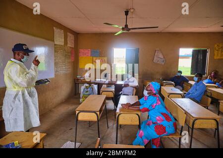 Lehrer, die PSA tragen, lehren Menschen, Gesichtsmasken an einem Programm für soziale Distanzierung zu tragen, das von einer Regierungsbehörde in Lagos, Nigeria, abgehalten wird. Stockfoto