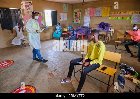 Lehrer, die PSA tragen, lehren Menschen, Gesichtsmasken an einem Programm für soziale Distanzierung zu tragen, das von einer Regierungsbehörde in Lagos, Nigeria, abgehalten wird. Stockfoto