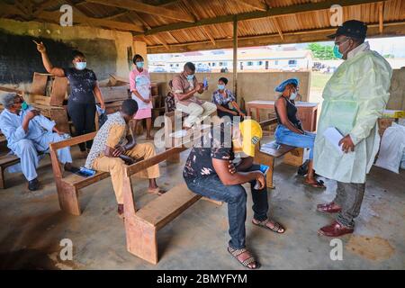 Lehrer, die PSA tragen, lehren Menschen, Gesichtsmasken an einem Programm für soziale Distanzierung zu tragen, das von einer Regierungsbehörde in Lagos, Nigeria, abgehalten wird. Stockfoto