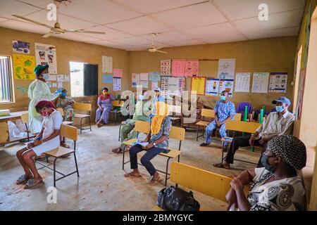 Lehrer, die PSA tragen, lehren Menschen, Gesichtsmasken an einem Programm für soziale Distanzierung zu tragen, das von einer Regierungsbehörde in Lagos, Nigeria, abgehalten wird. Stockfoto