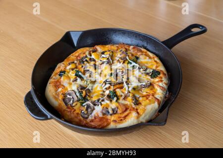 Hausgemachte vegetarische Pizza mit Pilzen, Spinat, Zwiebeln, Käse, Paprika und verschiedenen Gemüseauflagen und aromatischen Kräutern Stockfoto