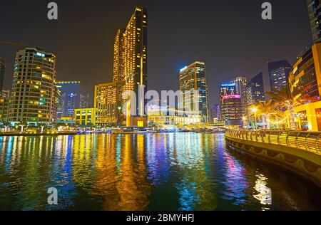 DUBAI, VAE - 2. MÄRZ 2020: Verbringen Sie einen romantischen Abend in Dubai Marina Genießen Sie die Lichter der Stadt, Silhouetten moderner Wolkenkratzer und ihre Reflektion in da Stockfoto