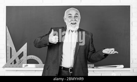 Spüren Sie den Erfolg. Trigonometrie-Lektion im Klassenzimmer. Lernen Sie hier. Lehrer für leitende Männer verwenden mathematische Werkzeuge. Bärtiger Dozent erklärt Geometrie auf der Tafel. Zurück zur Schule. Mathematische Grafikwerkzeuge. Stockfoto
