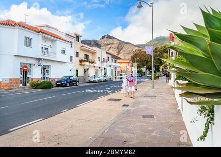 Touristen gehen entlang der Iglesia Avenue in der Altstadt von Santiago del Teide. Teneriffa, Spanien Stockfoto