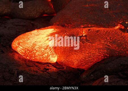 Detailansicht eines aktiven Lavastrom, heißem Magma entsteht aus einem Riss in der Erde, die glühende Lava erscheint in kräftigen Gelb- und Rottöne - Ort: Haw Stockfoto