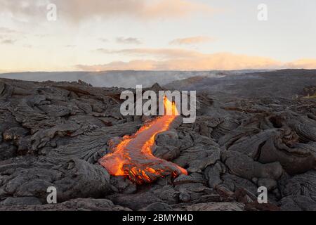 Aktiver Lavastrom auf Hawaii, Magma tritt aus einer Spalte, langsam abkühlend und in verschiedenen Mustern erstarrend, Morgenlicht, Tiefenwirkung - Ort: Stockfoto