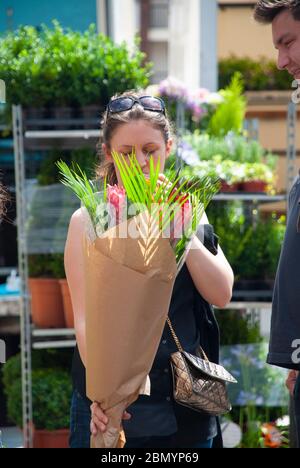 Frau mit Blumen auf dem Columbia Road Flower Market in East London, England, Großbritannien. Stockfoto