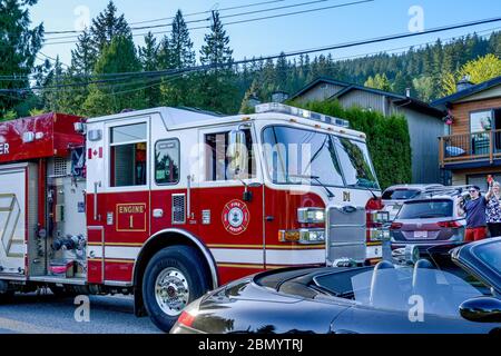 Lynn Valley Einwohner jubeln Ersthelfer als Feuerwehrauto durch Nachbarschaft, North Vancouver, British Columbia, Kanada passiert Stockfoto