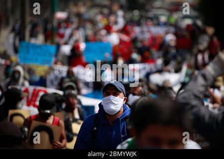 Quito, Ecuador. Mai 2020. Menschen, die Gesichtsmasken tragen und sozial distanziert sind, nehmen an einer Kundgebung gegen Bildungskürzungen während der Corona-Krise Teil. Angesichts der wirtschaftlichen Folgen der koronaepandemischen Pandemie hat die Regierung Ecuadors Kürzungen des Bildungshaushalts vorgeschlagen. Da es bis 14 Uhr mit einer Gesichtsmaske auf die Straße gehen darf, demonstrierten Schüler, Studenten, Lehrer und Dozenten gegen mögliche Kürzungen. Kredit: Juan Diego Montenegro/dpa/Alamy Live News Stockfoto