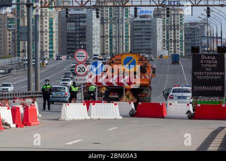 Moskau, Russland. 9. Mai 2020 EIN Verkehrspolizeikontrollpunkt am Eingang der Leningradskoje Autobahn aus Richtung der Moskauer Ringstraße, die Einreise in die Stadt durch elektronischen Pass im Rahmen zusätzlicher vorbeugender Maßnahmen gegen die Ausbreitung des Coronavirus COVID-19 Infektion eingeschränkt. Auf dem schwarzen Banner (rechts) steht: "Der Eingang zur Stadt nur durch elektronischen Pass. Achtung' Stockfoto