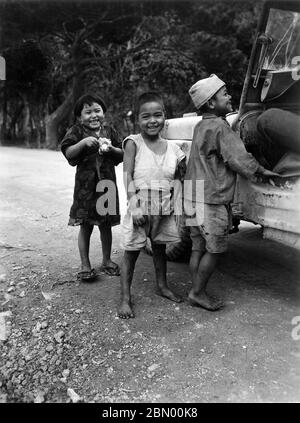 [ 1946 Japan - Okinawan Kinder ] - Okinawan Kinder betteln um Süßigkeiten neben einem US-Militär Jeep, 1946 (Showa 21). Silberdruck mit Gelatine aus dem 20. Jahrhundert. Stockfoto