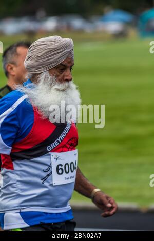 Ältere Männer ( 60 bis 70 ), die im 200 M Rennen antreten. Ostindischer Läufer mit großem weißen Bart. Stockfoto