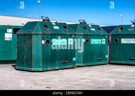 Nahaufnahme Foto von großen öffentlichen Recycling grüne Metall-Container auf dem Parkplatz für die Entsorgung von verschiedenen Arten von Glas - farbig und transparent.sonnig Stockfoto