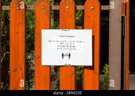 COVID-19 Coronavirus Schild: Bitte 1.5 m Abstand halten. Warnung am Zaun der Eisdiele, Sopron, Ungarn Stockfoto