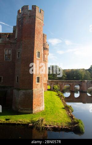 Ein Blick auf einen der Ecktürme, Graben und Fußgängerbrücke in Herstmonceux Castle, East Sussex, Großbritannien Stockfoto