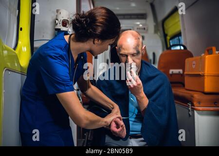 Eine Ärztin, die den Puls ihrer Patientin überprüft und mit ihr spricht Ihn zu trösten Stockfoto