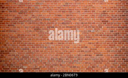 Rötliche Ziegelwand eines alten Gebäudes. Hintergrund einer Mauer mit alten Steinen. Alte Mauer einer Kirche Stockfoto