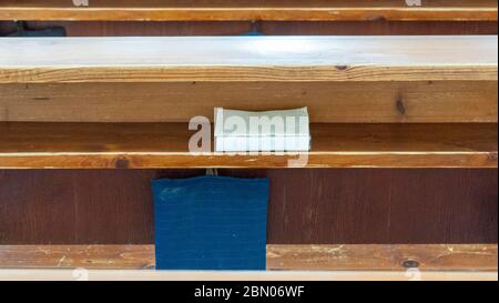 Holzbänke in der katholischen Kirche. Katholische Tempel Sitze, Verschwommener Hintergrund. Religiöser Hintergrund. Göttliches Licht, Gnade, Hoffnung Konzept. Stockfoto