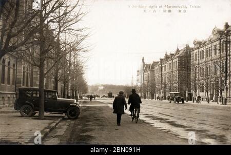 [ Japan der 1920er Jahre - Marunouchi Business District in Tokyo ] - Fußgänger, Radfahrer und Autos im Marunouchi District in Tokio. Die ersten Gebäude wurden in diesem ehemaligen Sumpfland im Jahre 1894 (Meiji 27) gebaut. Als der Bahnhof Tokio 1914 eröffnet wurde (Taisho 3), wurde er Tokios führende Geschäftsadresse. Wegen der vielen Backsteinbauten wurde es auch als „Londontown“ bezeichnet. Vintage-Postkarte des 20. Jahrhunderts. Stockfoto