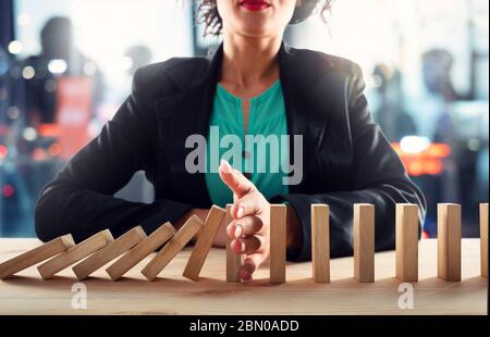 Geschäftsfrau hält eine Kette fallen wie Domino Spiel. Konzept zur Vermeidung der Krise und Ausfall im Geschäft. Stockfoto