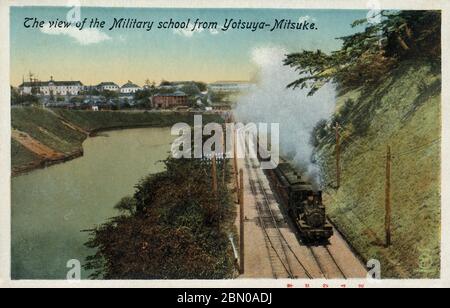 [ 1910 Japan - Dampflokomotive in Shinjuku, Tokyo ] - EINE Dampflokomotive, die einen Personenzug zieht, fährt entlang des Sotobori-Grabens, wie von Yotsuya-Mitsuke (四谷見附) in Shinjuku, Tokyo gesehen. Diese Route ist jetzt die Chuo-Sobu Linie (中央・総武緩行線). Das weiße Gebäude im Hintergrund ist die Kaiserliche Japanische Armee Akademie (陸軍士官学校, Rikugun Shikan Gakko) in Ichiya (市谷), die Hauptoffizierschule für die Kaiserliche Japanische Armee. Vintage-Postkarte des 20. Jahrhunderts. Stockfoto