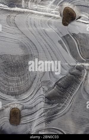 Nahaufnahme von Eisformationen mit eleganten Linien und Flussgestein während des Frühlings schmelzen entlang des Yukon River. Das kreative Chaos der Natur und die zufällige Eleganz Stockfoto