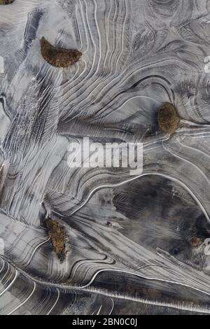 Nahaufnahme von Eisformationen mit eleganten Linien und Flussgestein während des Frühlings schmelzen entlang des Yukon River. Das kreative Chaos der Natur und die zufällige Eleganz Stockfoto