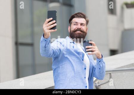 Online chatten und mit Freunden treffen. Bärtiger Mann chatte online über Handy. Online-Meeting. Audio- oder Videokonferenzen auf mobilen Geräten. Online-Videoanruf. Smartphone-Kommunikation. Stockfoto