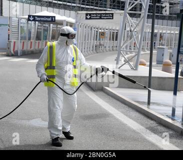 Rom, Italien. Mai 2020. Ein Flughafenmitarbeiter sprüht am 11. Mai 2020 auf dem Flughafen Fiumicino in Rom Desinfektionsmittel als vorbeugende Maßnahme gegen COVID-19 ein. Die COVID-19-Pandemie hat nach einem täglichen Anstieg von 179 Todesfällen in Italien 30,739 Menschenleben gefordert, so die jüngsten Daten, die das Katastrophenschutzministerium des Landes am Montag veröffentlicht hat. Kredit: Alberto Lingria/Xinhua/Alamy Live News Stockfoto