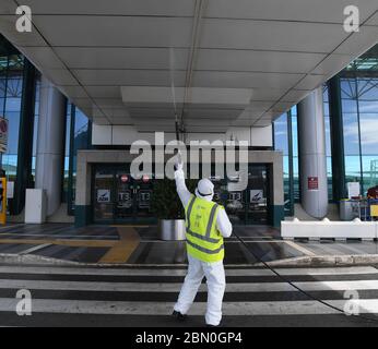 Rom, Italien. Mai 2020. Ein Flughafenmitarbeiter sprüht am 11. Mai 2020 auf dem Flughafen Fiumicino in Rom Desinfektionsmittel als vorbeugende Maßnahme gegen COVID-19 ein. Die COVID-19-Pandemie hat nach einem täglichen Anstieg von 179 Todesfällen in Italien 30,739 Menschenleben gefordert, so die jüngsten Daten, die das Katastrophenschutzministerium des Landes am Montag veröffentlicht hat. Kredit: Alberto Lingria/Xinhua/Alamy Live News Stockfoto