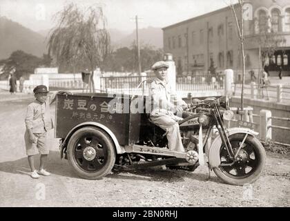 [ 1930 Japan - HMC Heckfahrzeug Motorrad, Kobe ] - EIN Mann, der Holzkohlebriketts verkauft, posiert auf einem hinteren Auto Liefermotorrad in Kobe. Das Motorrad ist ein Trike, das von der Firma Hyogo Motors (HMC, 兵庫モータース) hergestellt wird. Für Trikes unter 750cc wurde kein Führerschein benötigt, was sie in Japan extrem beliebt macht. Das Foto ist vom 12. Mai 1930 datiert. Nur wenige japanische Ladetrike überlebten den Krieg, was dieses Foto zu einem wichtigen historischen Dokument machte. Silberdruck mit Gelatine aus dem 20. Jahrhundert. Stockfoto