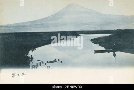 [ 1900er Japan - Fuji ] - Fuji (富士山) vom Fluss Numakawa (沼川) in der Präfektur Shizuoka aus gesehen. Im Vordergrund ist ein kleines Boot zu sehen. Vintage-Postkarte des 20. Jahrhunderts. Stockfoto