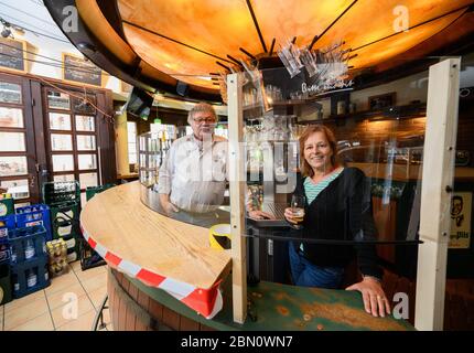 Mainz, Deutschland. Mai 2020. Burkhard und Janine Geibel-Emden, Mieter des traditionellen Pubs zur Andau, stehen hinter einem Spießhüter an der Bar. Die Taverne im Stadtzentrum will unter Einhaltung der Corona Hygienevorschriften wieder eröffnet werden. Die Landesregierung in Rheinland-Pfalz hat zum 13. Mai grünes Licht für das Restaurant gegeben. Quelle: Andreas Arnold/dpa/Alamy Live News Stockfoto