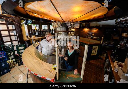 Mainz, Deutschland. Mai 2020. Burkhard und Janine Geibel-Emden, Mieter des traditionellen Pubs zur Andau, stehen hinter einem Spießhüter an der Bar. Die Taverne im Stadtzentrum will unter Einhaltung der Corona Hygienevorschriften wieder eröffnet werden. Die Landesregierung in Rheinland-Pfalz hat zum 13. Mai grünes Licht für das Restaurant gegeben. Quelle: Andreas Arnold/dpa/Alamy Live News Stockfoto